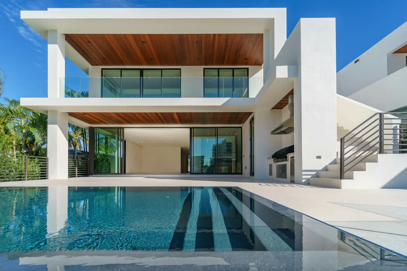 Finished Terrace House: white frame, timber soffits, a pool in front