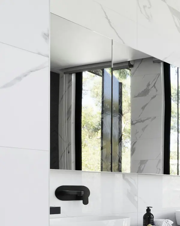 White veined marble around a bathroom mirror